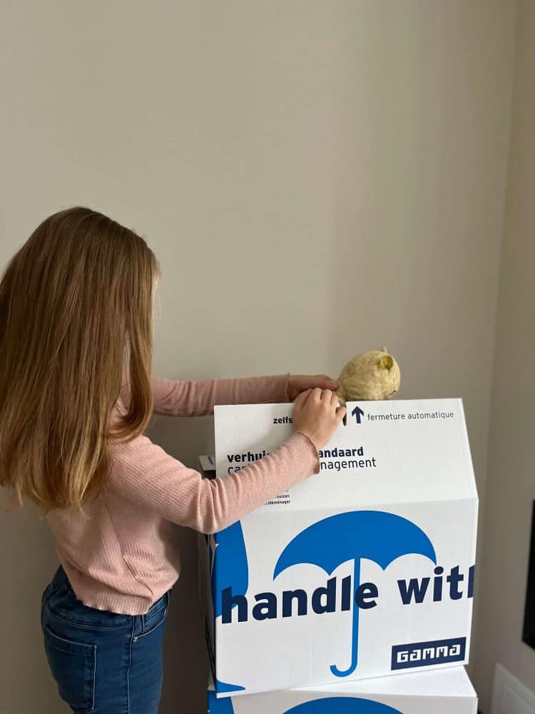 verhuizenkind een kind die verhuisdozen inpakt